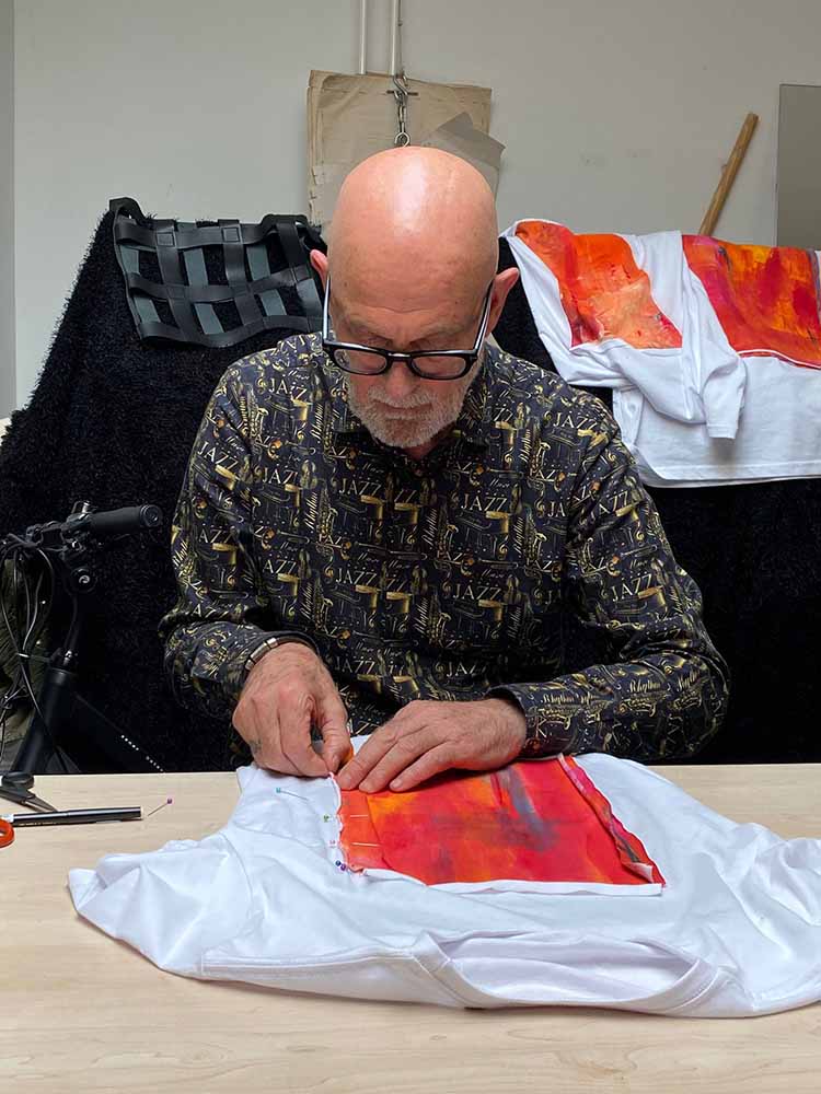 Kunstenaar Vincent Welten bewerkt een T-shirt met eeen van zijn schildereijen op katoen en textielverf