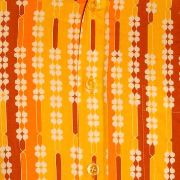 Detailopname van de ademende katoenen stof en het geometrische jaren zeventig shamrock-printpatroon in oranje, lichtbruin en 