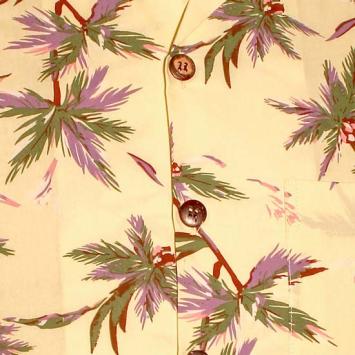 Detailopname van de zomerse palmbladeren print in lila en bruin op het luchtige, katoenen Chenaski overhemd met retro knoopje